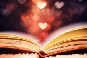 Open book against heart shaped glitter, Valentines day concept for celebrating books blog title